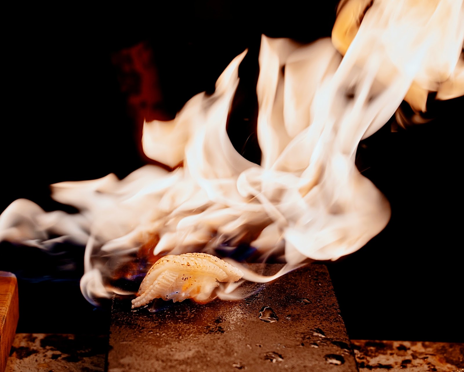 Flames at the counter — the fire-seared dish