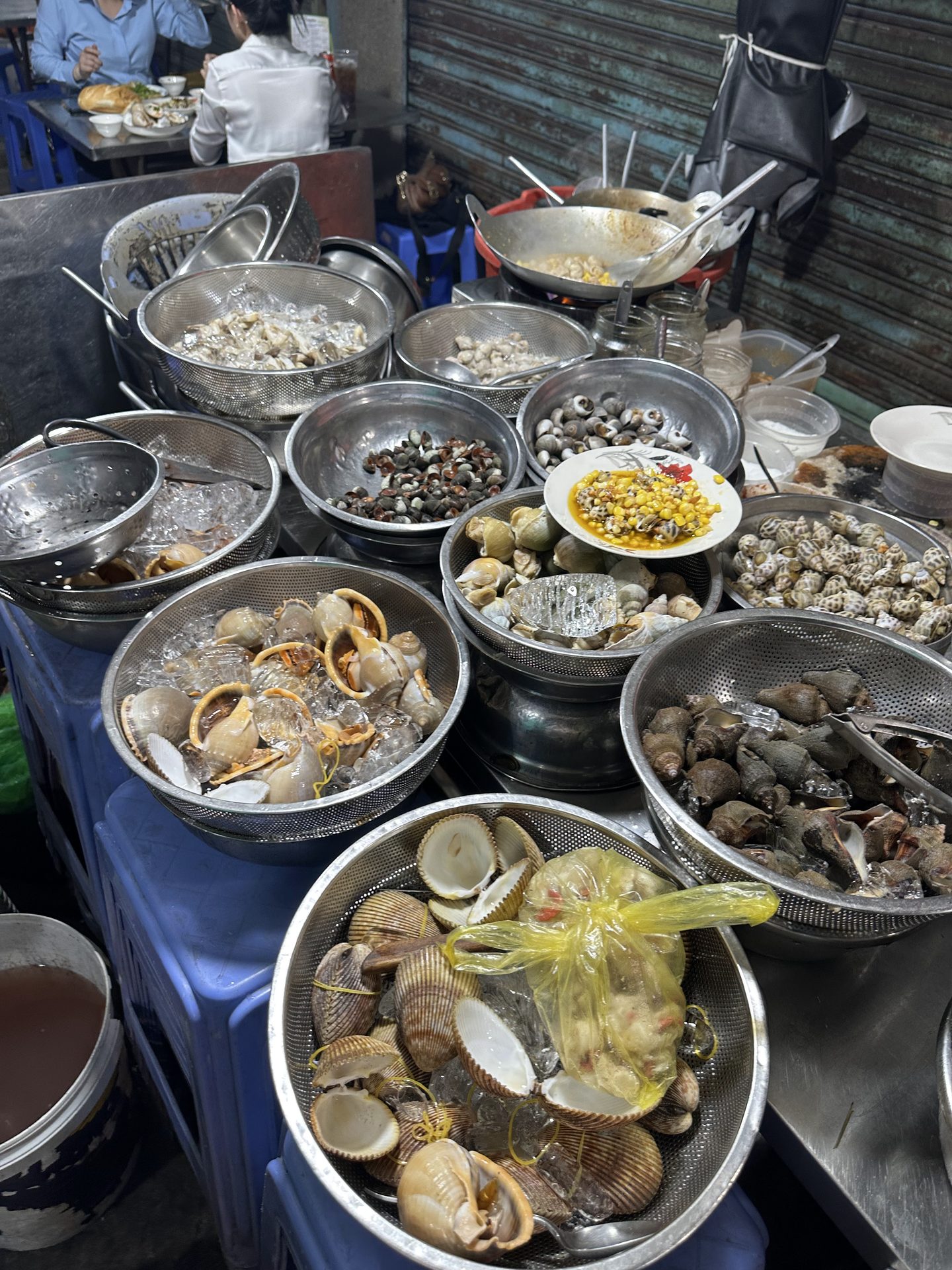 Ốc tươi bày trong rổ trên đá tại chợ Bàn Cờ
