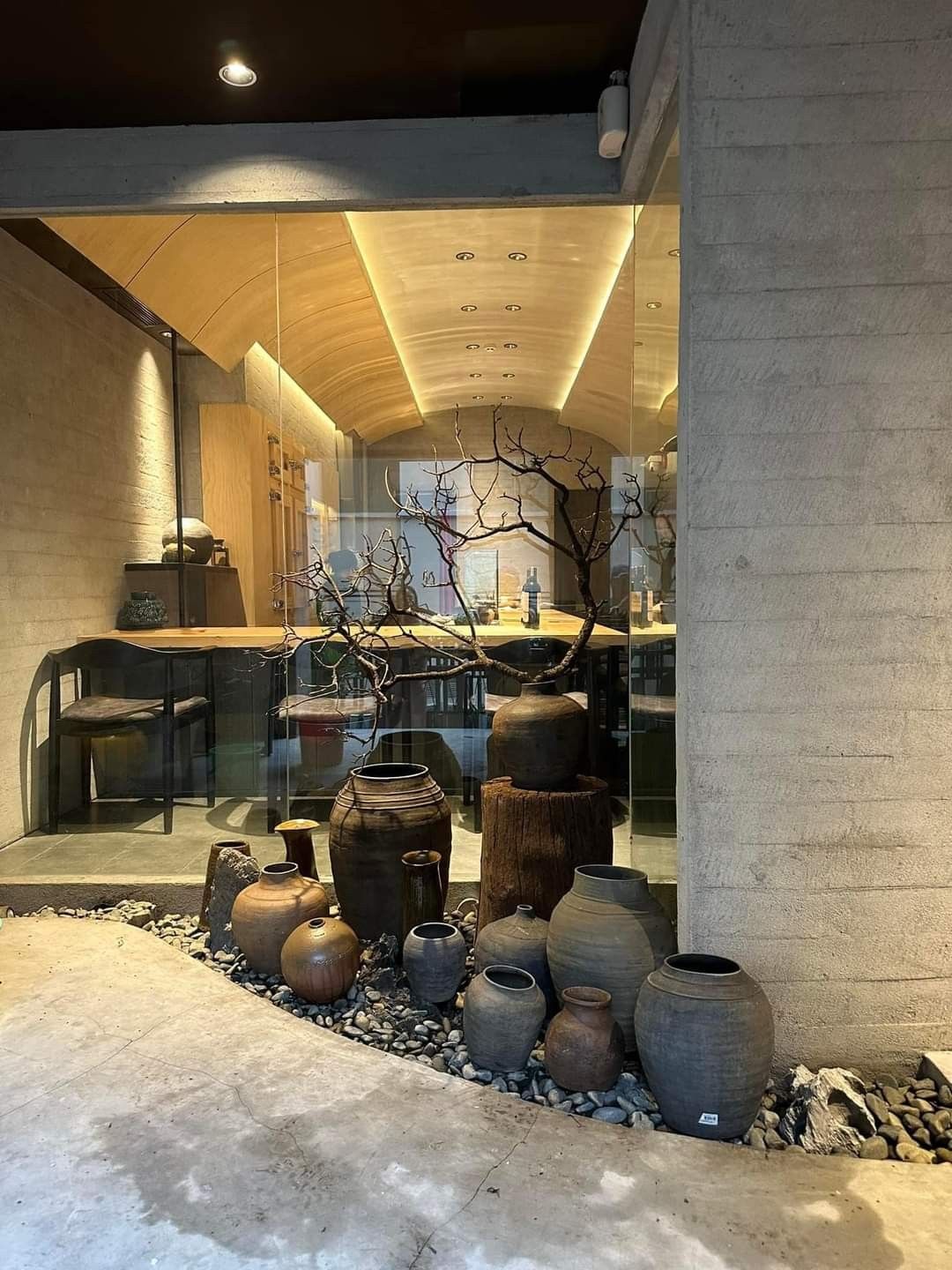 The glowing curved wooden ceiling seen through the glass entrance of Omakase Niku by K