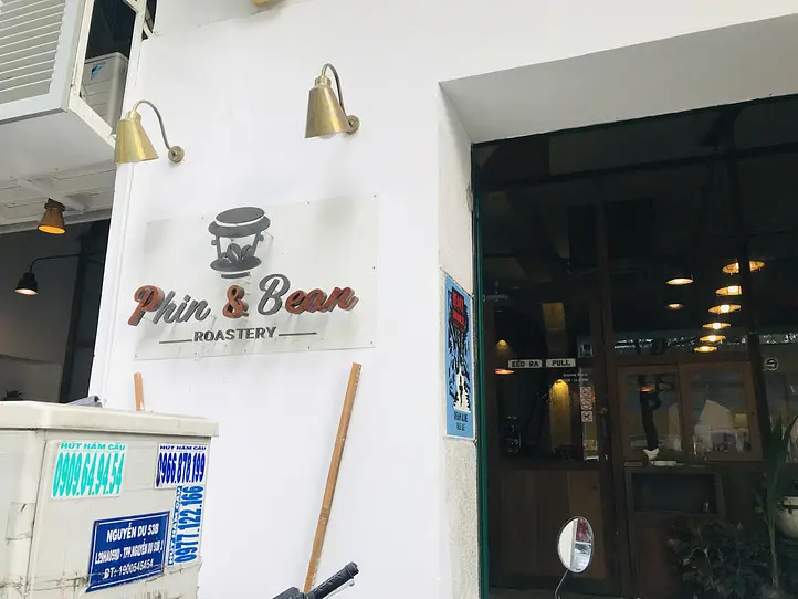 The entrance with the logo sign and brass wall lamps