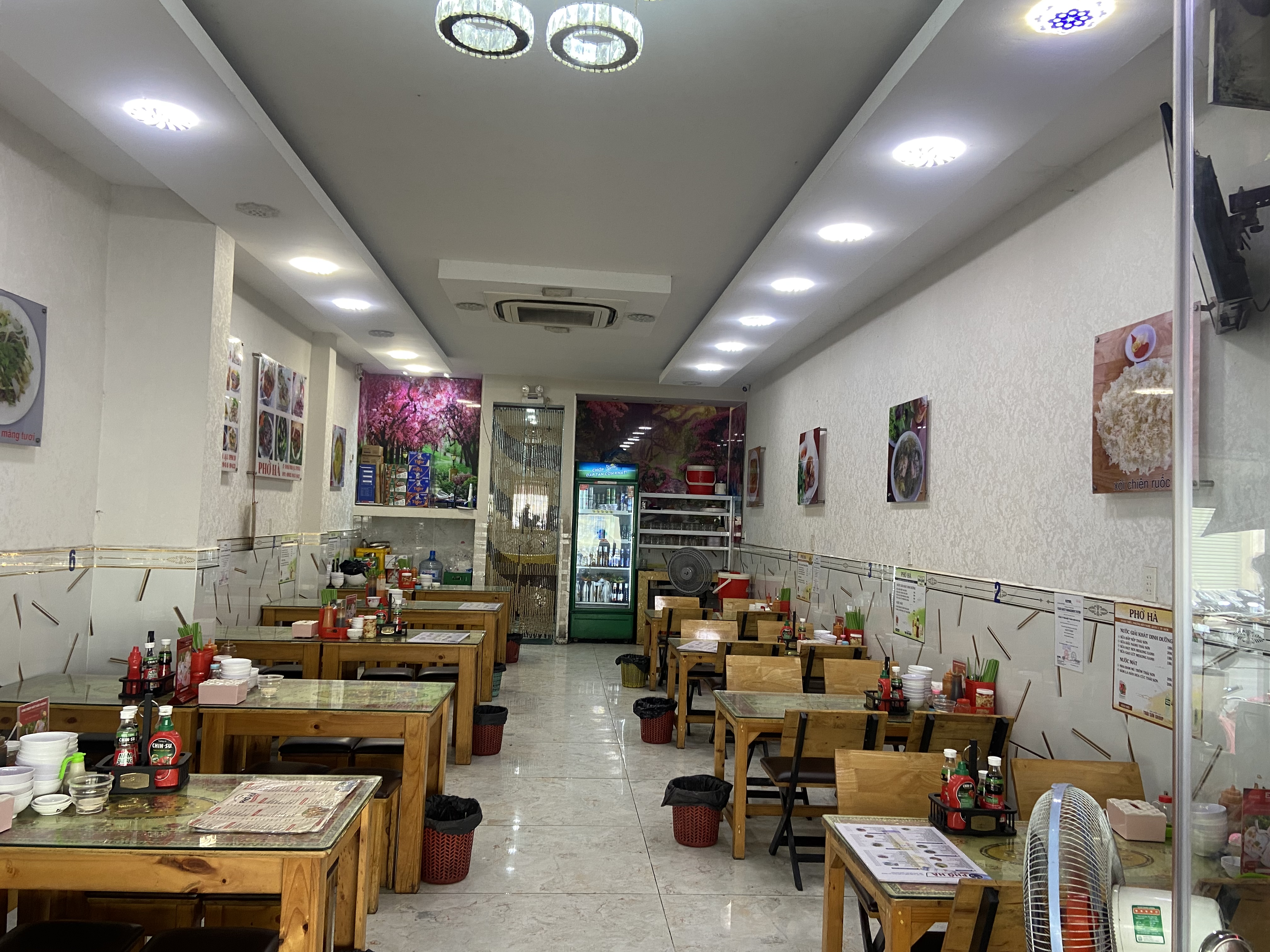 Phòng ăn Phở Hà với bàn gỗ và khay gia vị
