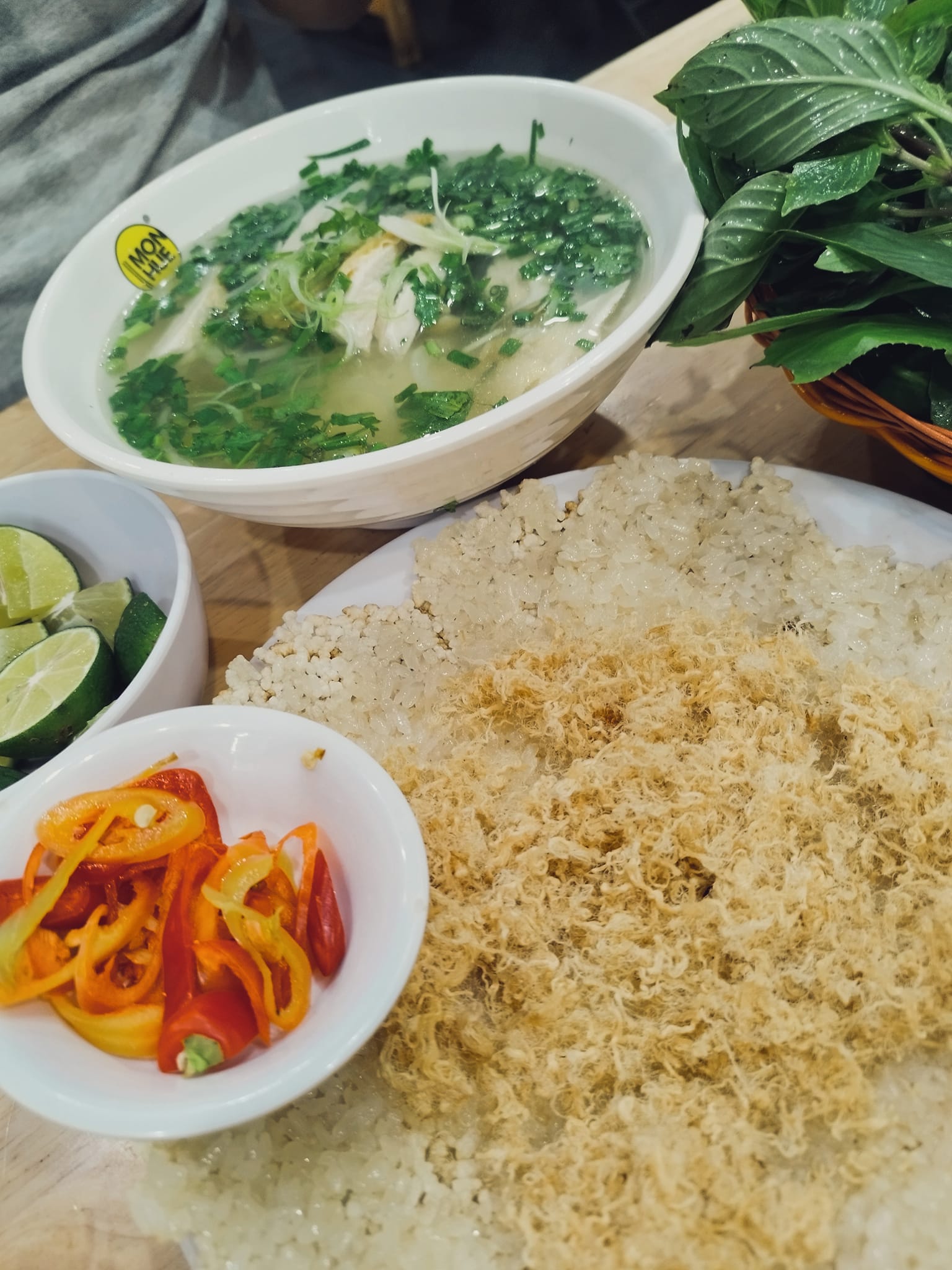 Phở gà kèm rổ rau thơm và đĩa xôi chiên ruốc giòn