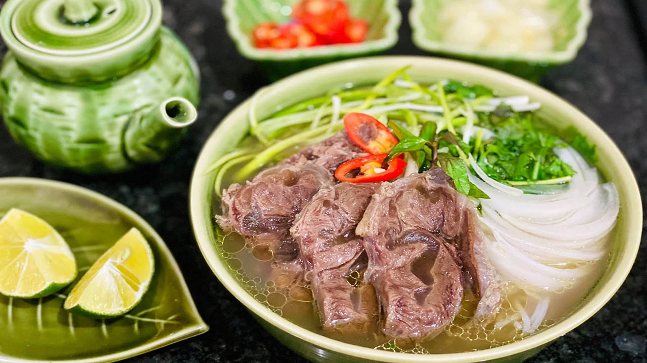 The Pho Hang Nam Dinh beef-shank pho bowl — noodles, beef, green onions