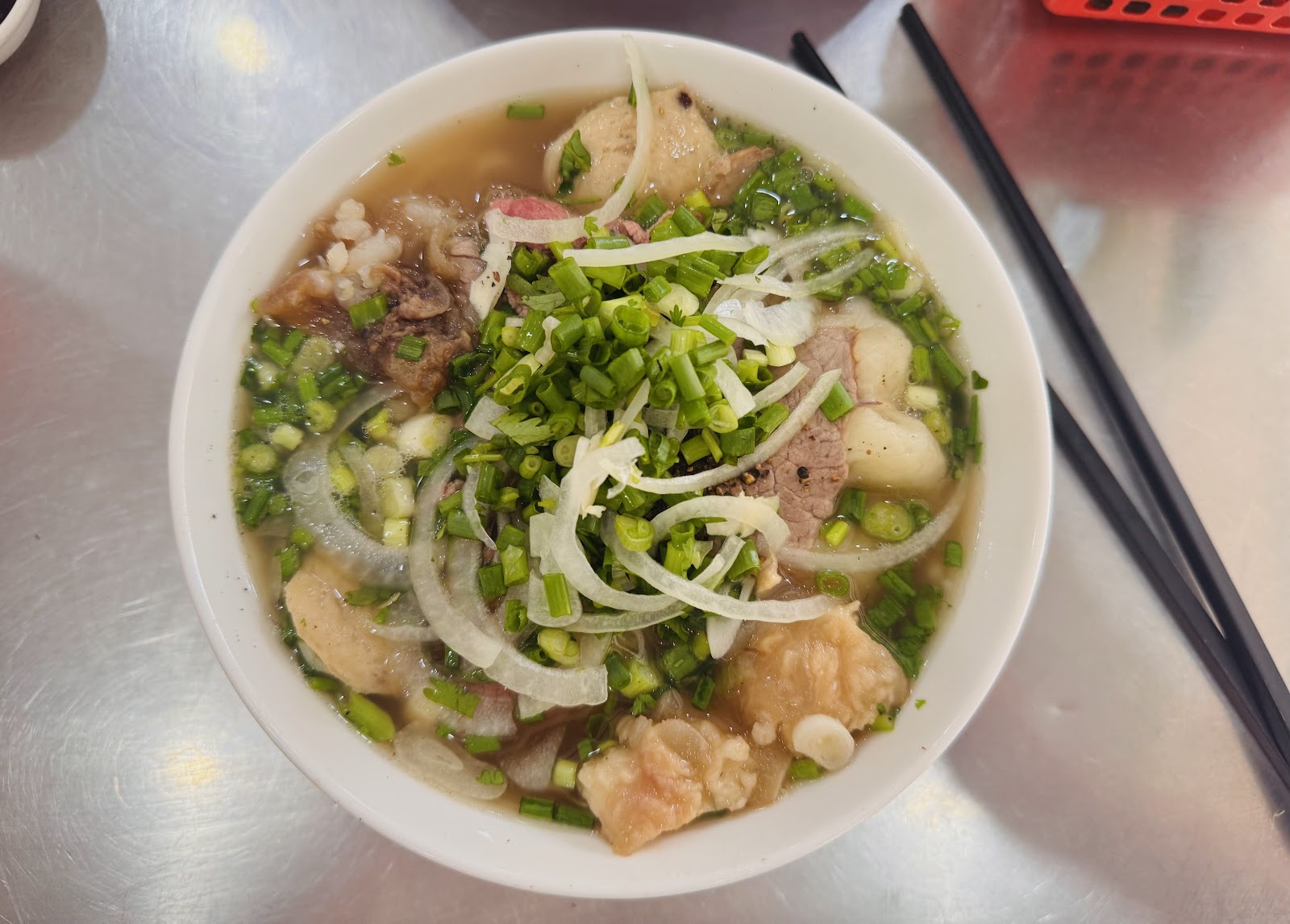 Beef-pho bowl with golden fried shallots on a breakfast table