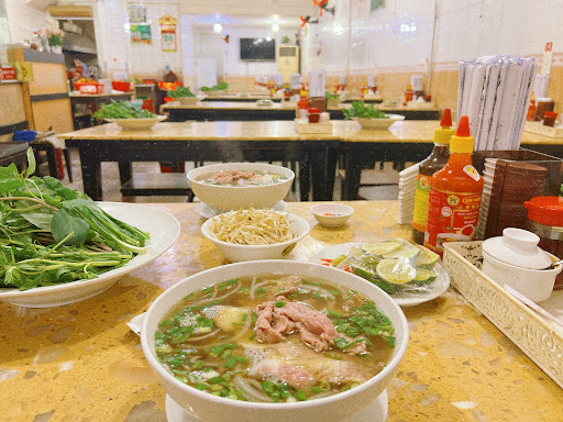 Bàn đầy những tô phở lớn Phở Hùng