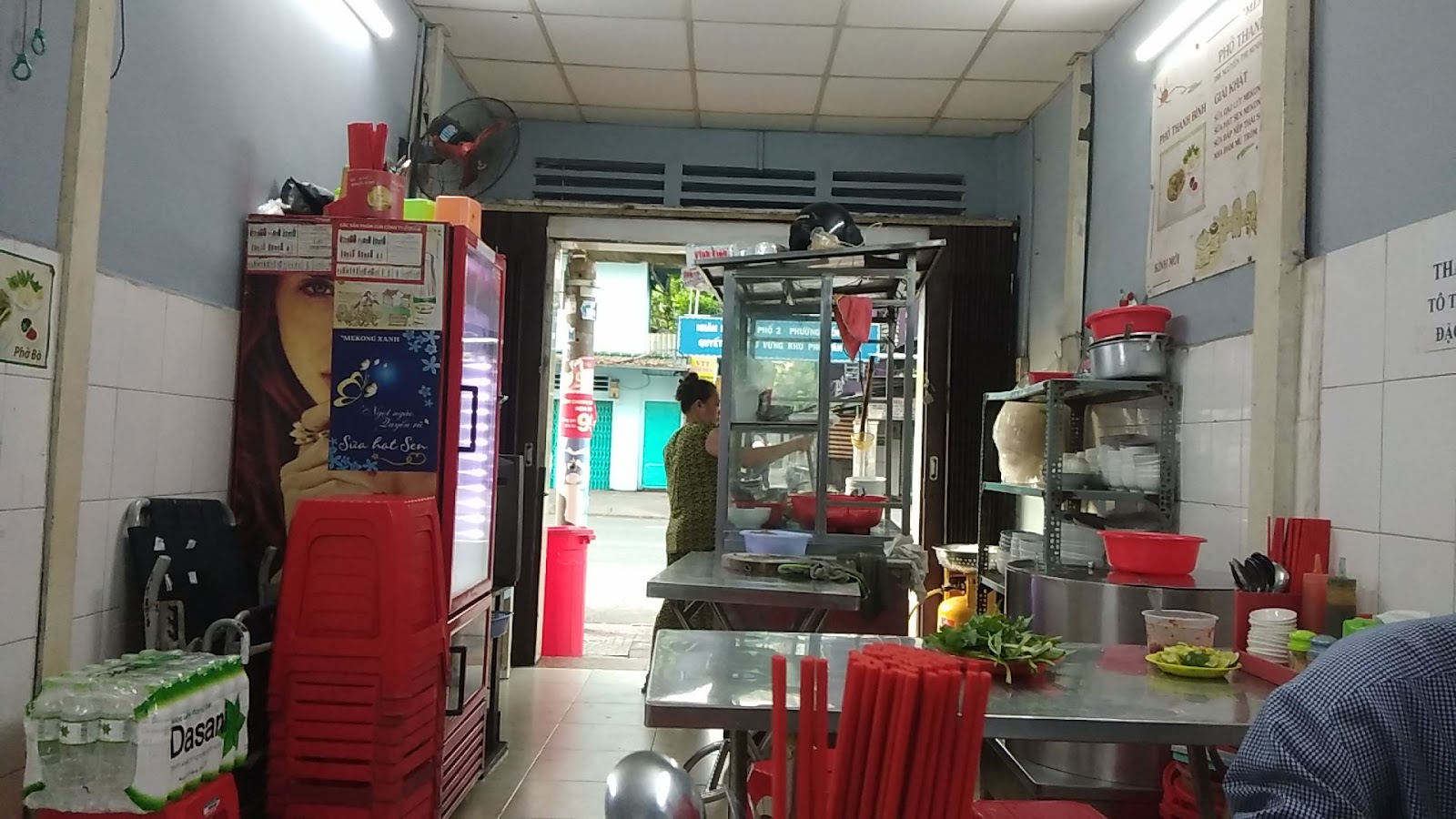 Inside the shop — steel tables, red plastic stools