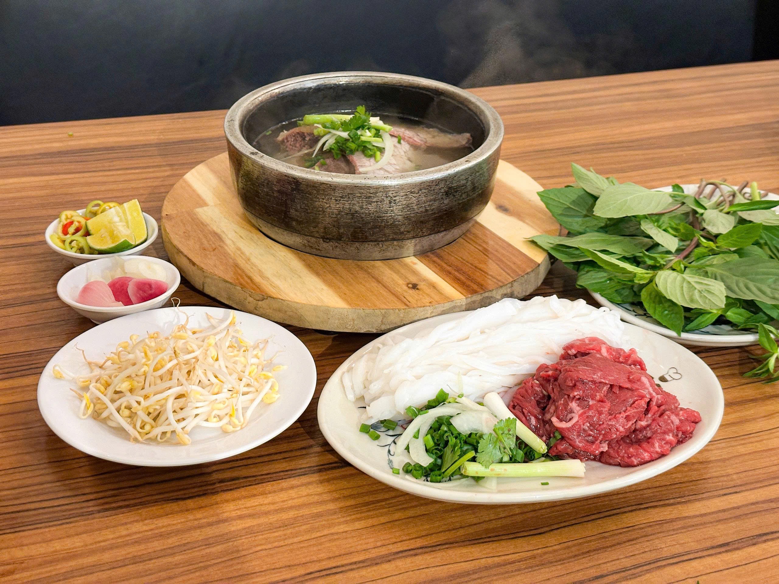 나무 받침 위에서 아직 끓고 있는 돌솥 쌀국수