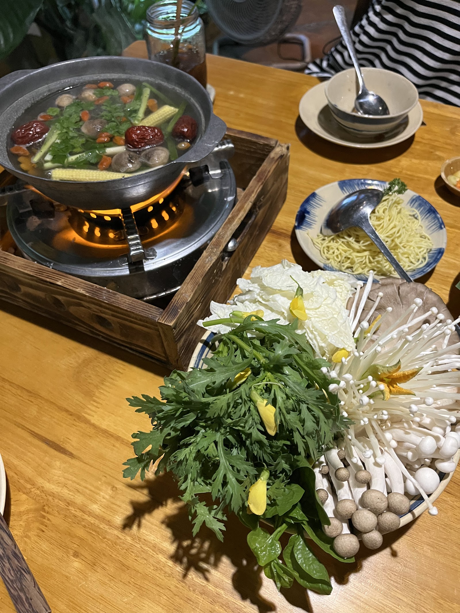 Nồi lẩu chay sôi với nấm và rau xanh