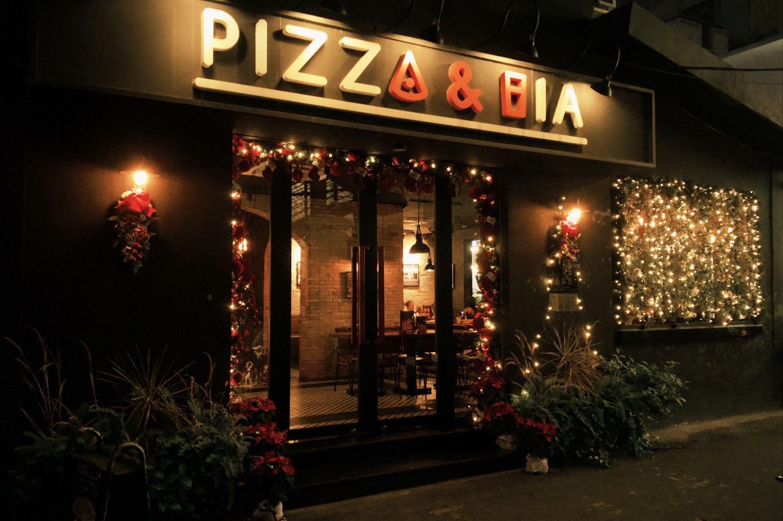 Pizza & Bia storefront at night