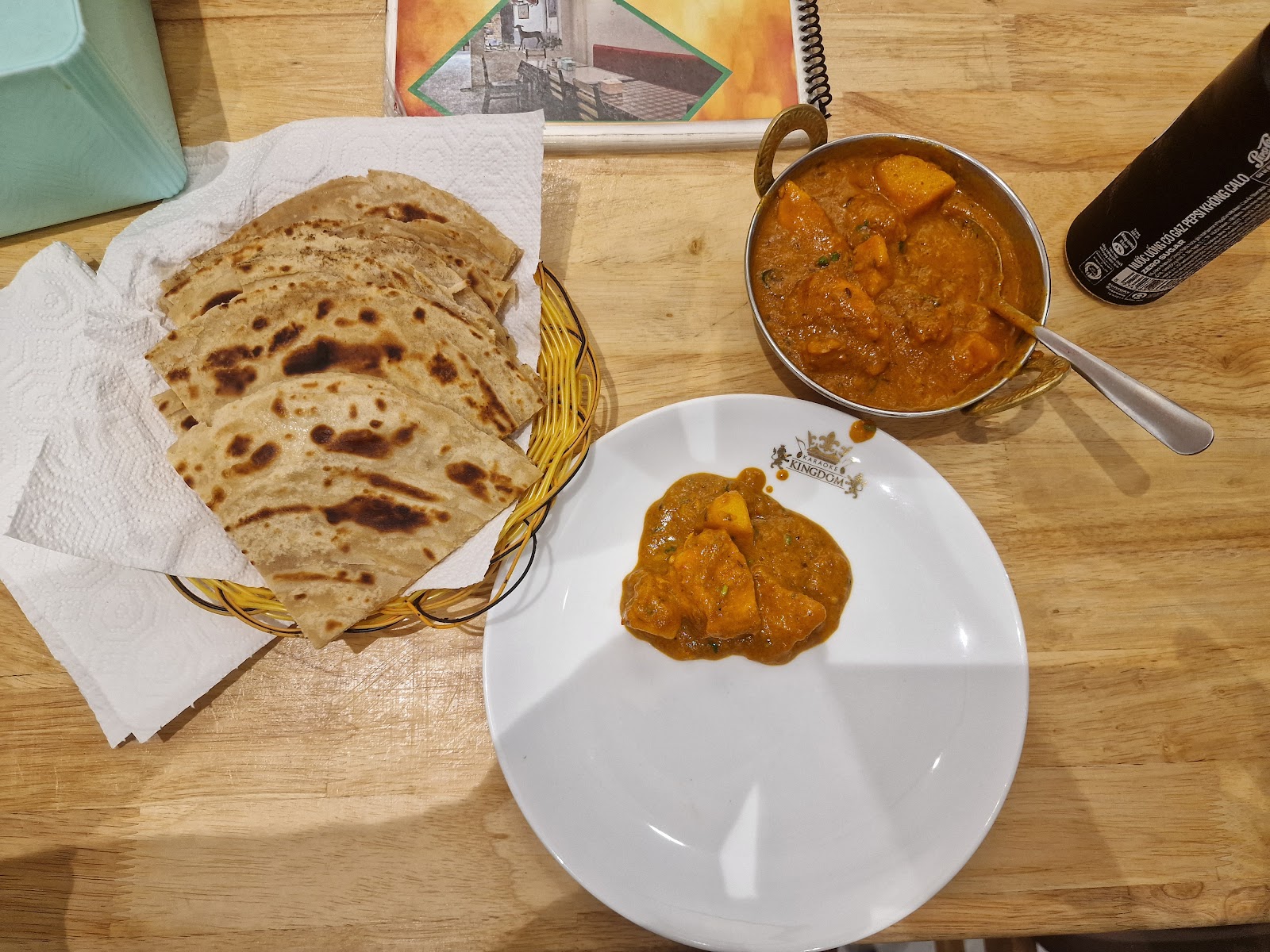 Bàn ăn nhìn từ trên: paratha và cà ri gà trong nồi đồng