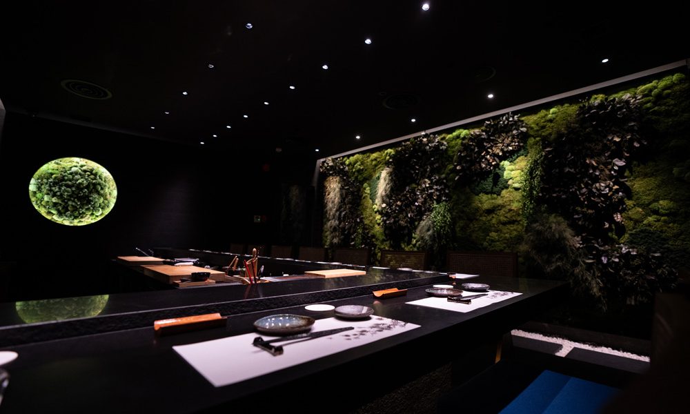 The glowing moss-moon wall above Roka Fella's dark counter
