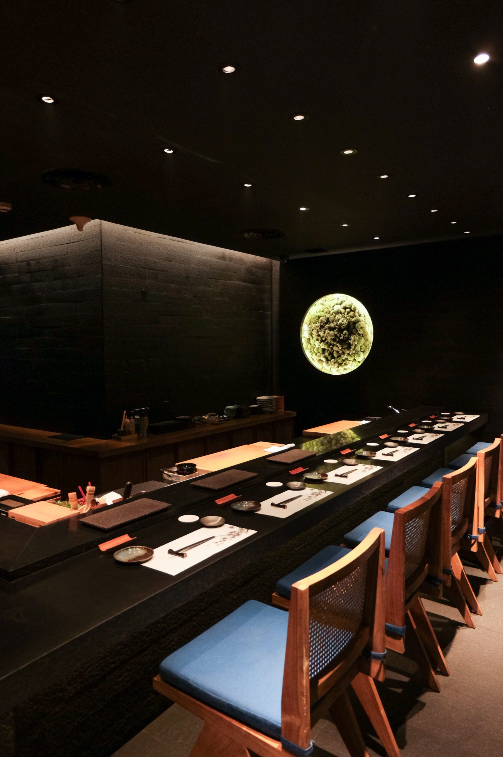 Roka Fella's dark room with the counter and moss-moon wall
