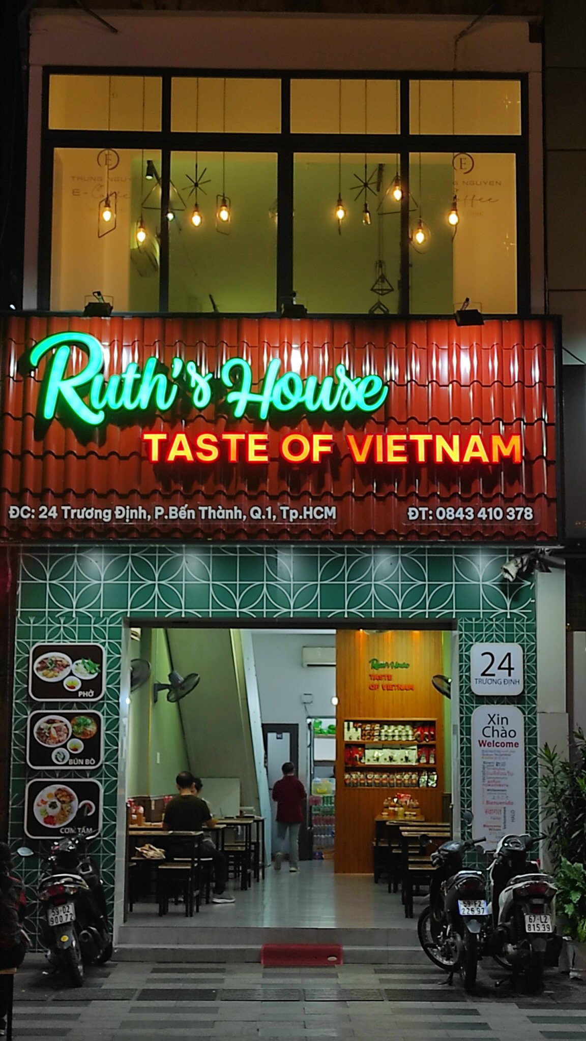 Ruth's House storefront at night with its illuminated sign