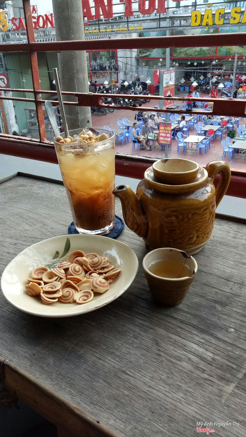 Ban công: ly đá me đậu phộng, ấm trà đất, bánh tai heo, nhìn xuống phố