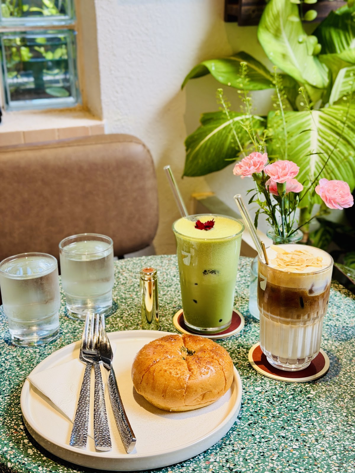 Sancara Caffe — matcha đá, cà phê đá và bánh trên bàn terrazzo