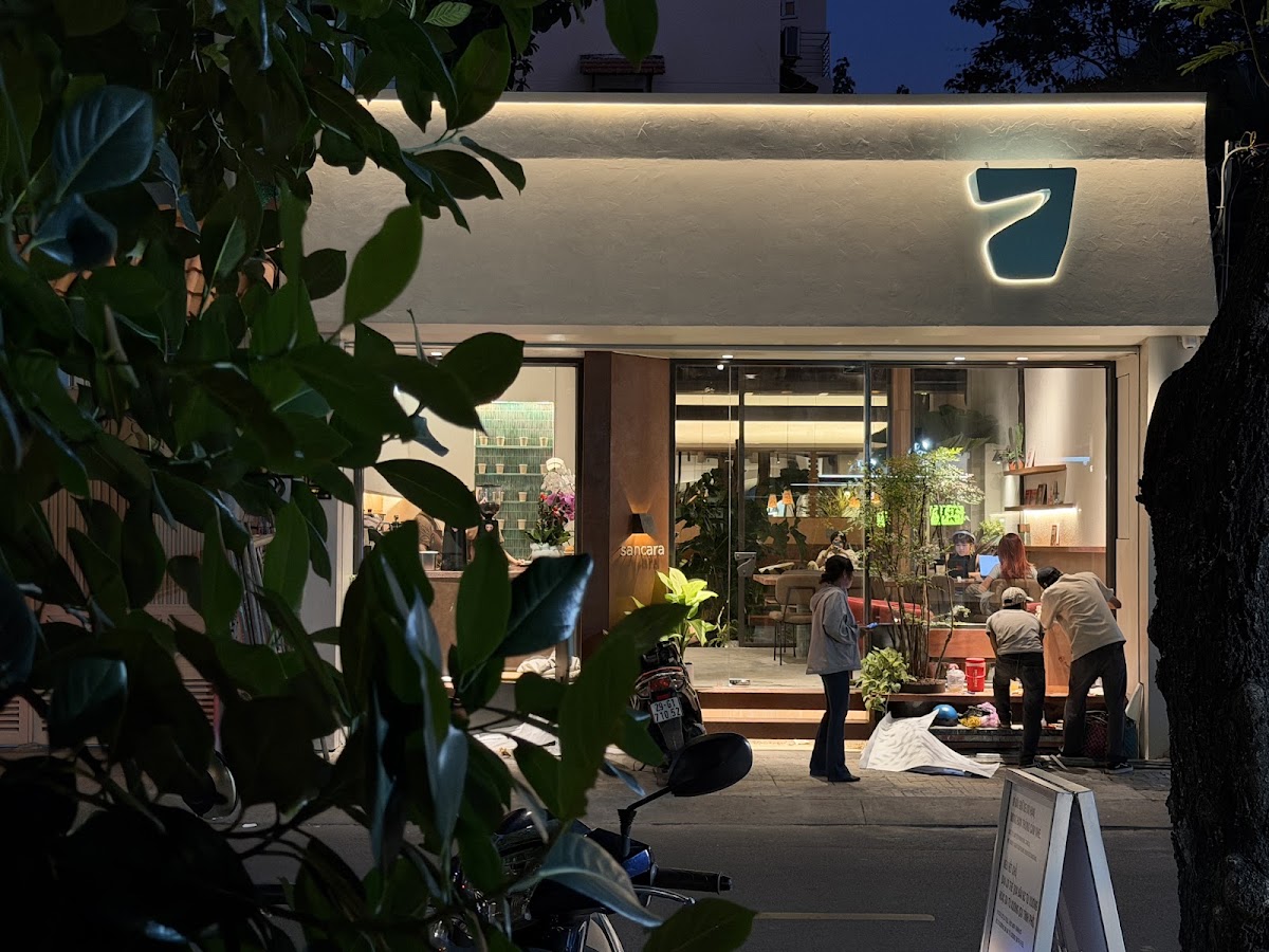 Sancara Caffe — mặt tiền ban đêm với logo teal phát sáng