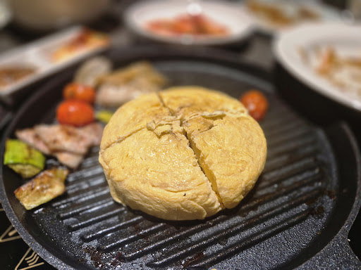 The golden Castella egg roll grilled at the center of the cast-iron grill