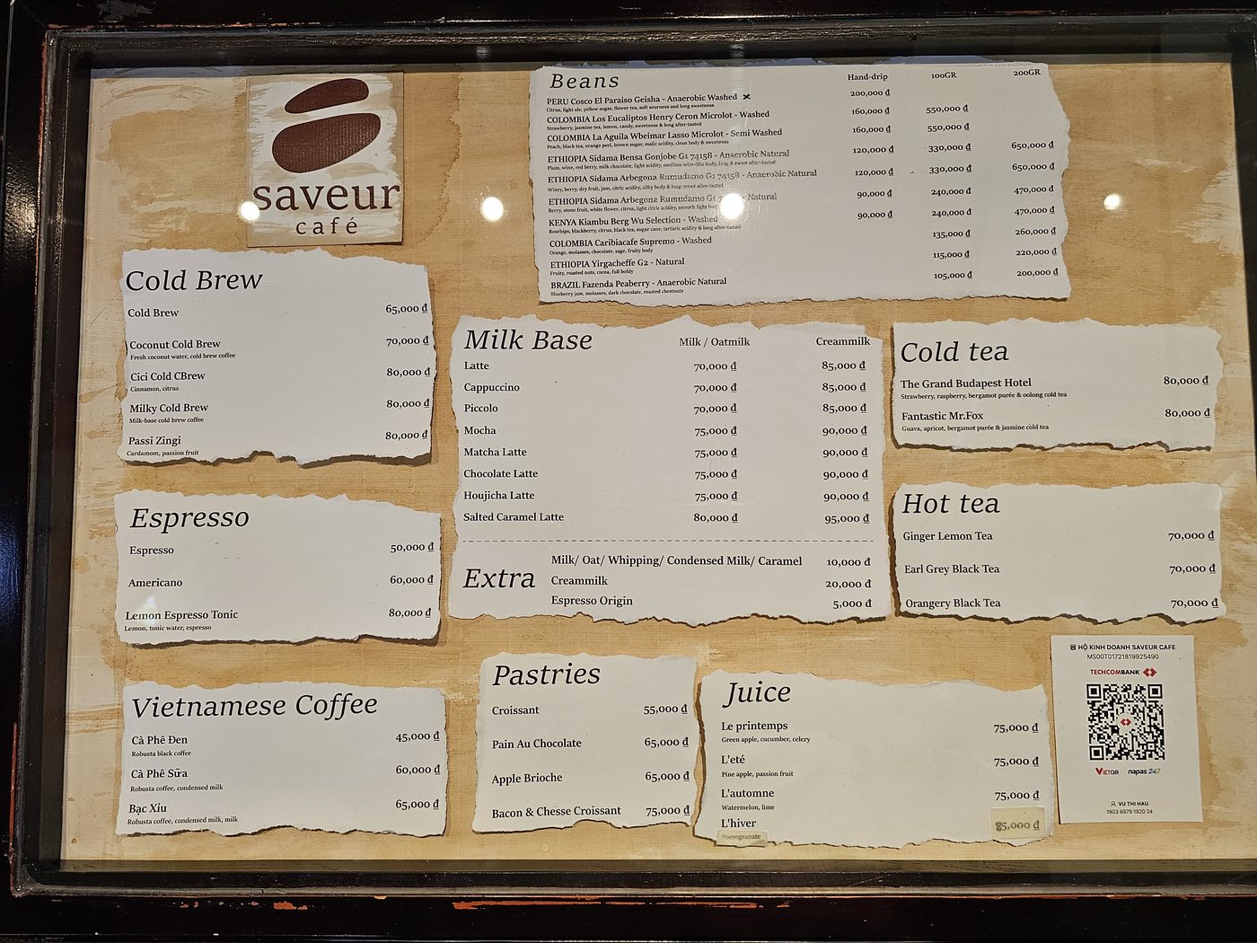 Saveur Café — the real menu board: dark wood frame, torn-edge cards on kraft (Duy Le photo, Apr 2026)