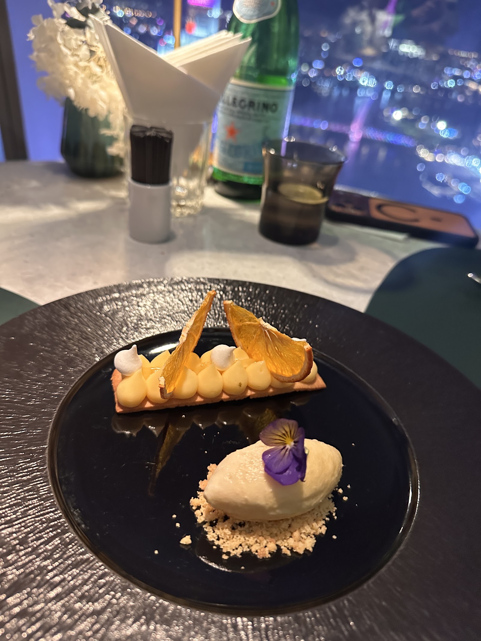 The lemon tart with candied orange, a violet and a quenelle