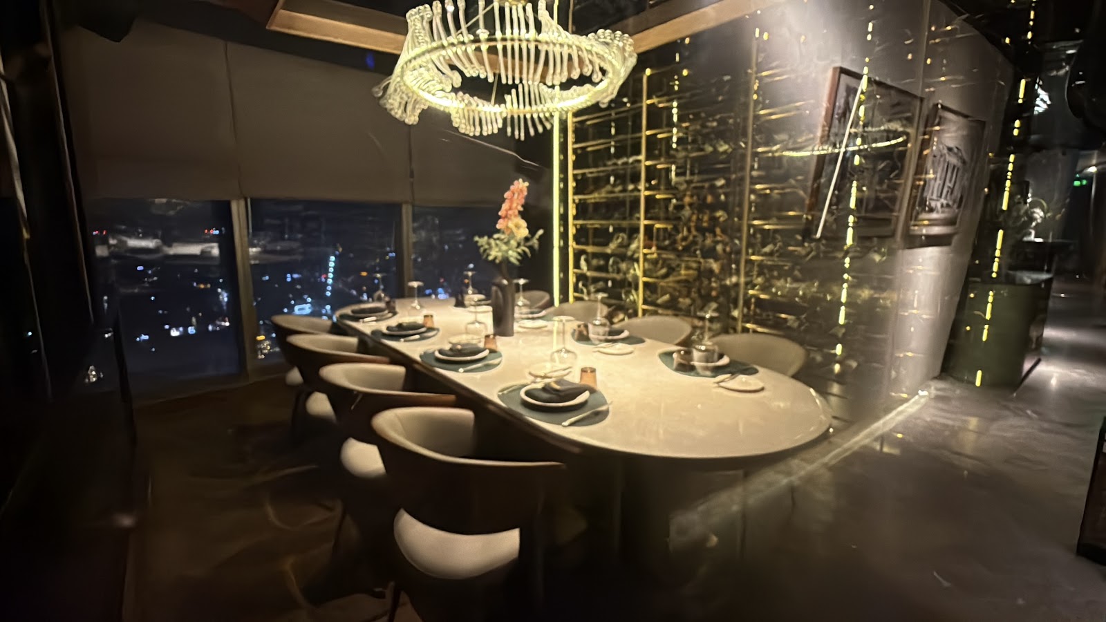 The evening dining room, city lights beyond the glass