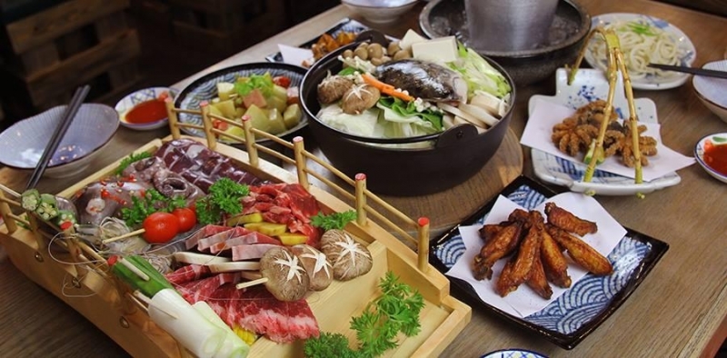 Khay thịt bày trên cầu gỗ và nồi lẩu