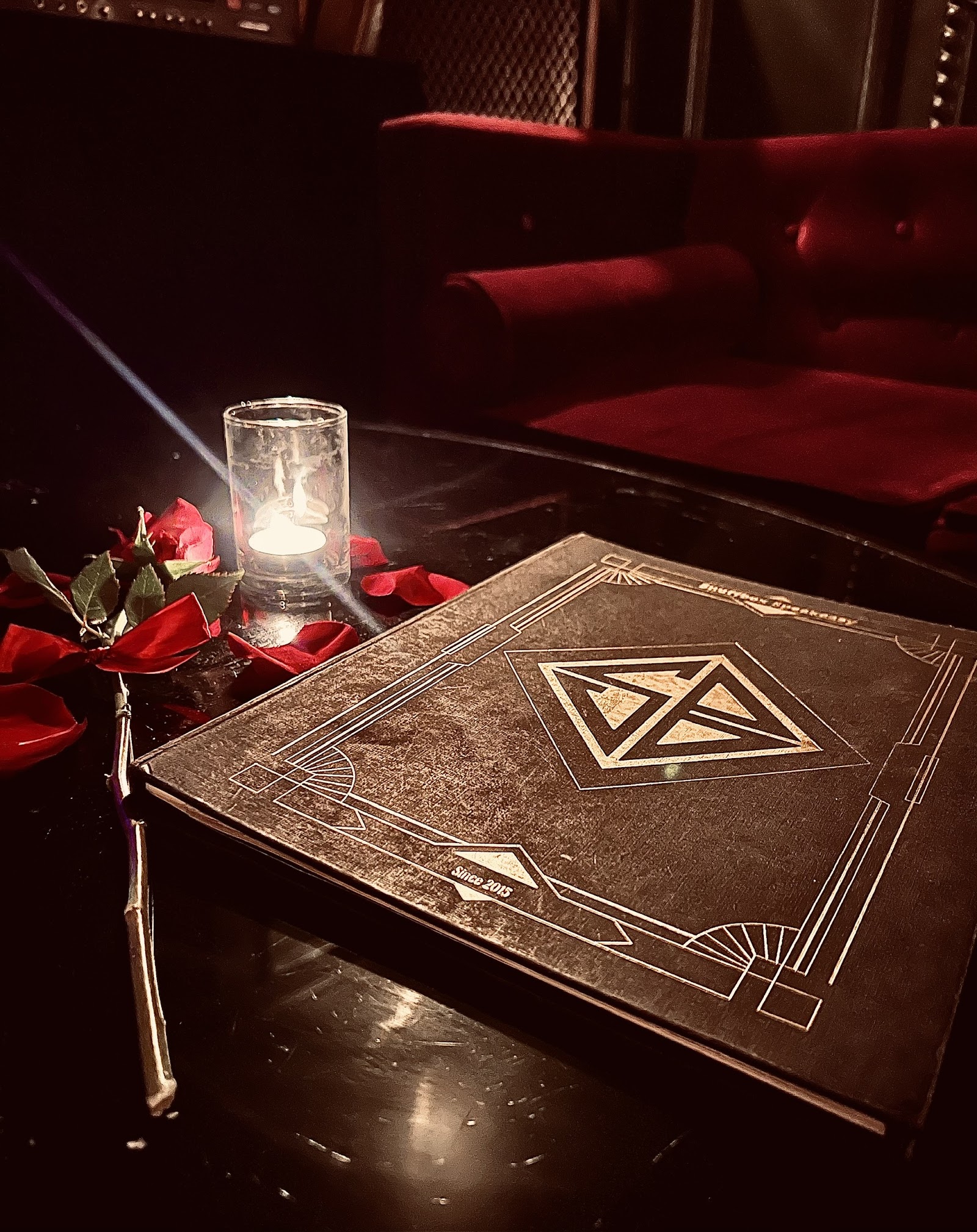 Không gian speakeasy — ánh nến và gỗ sẫm
