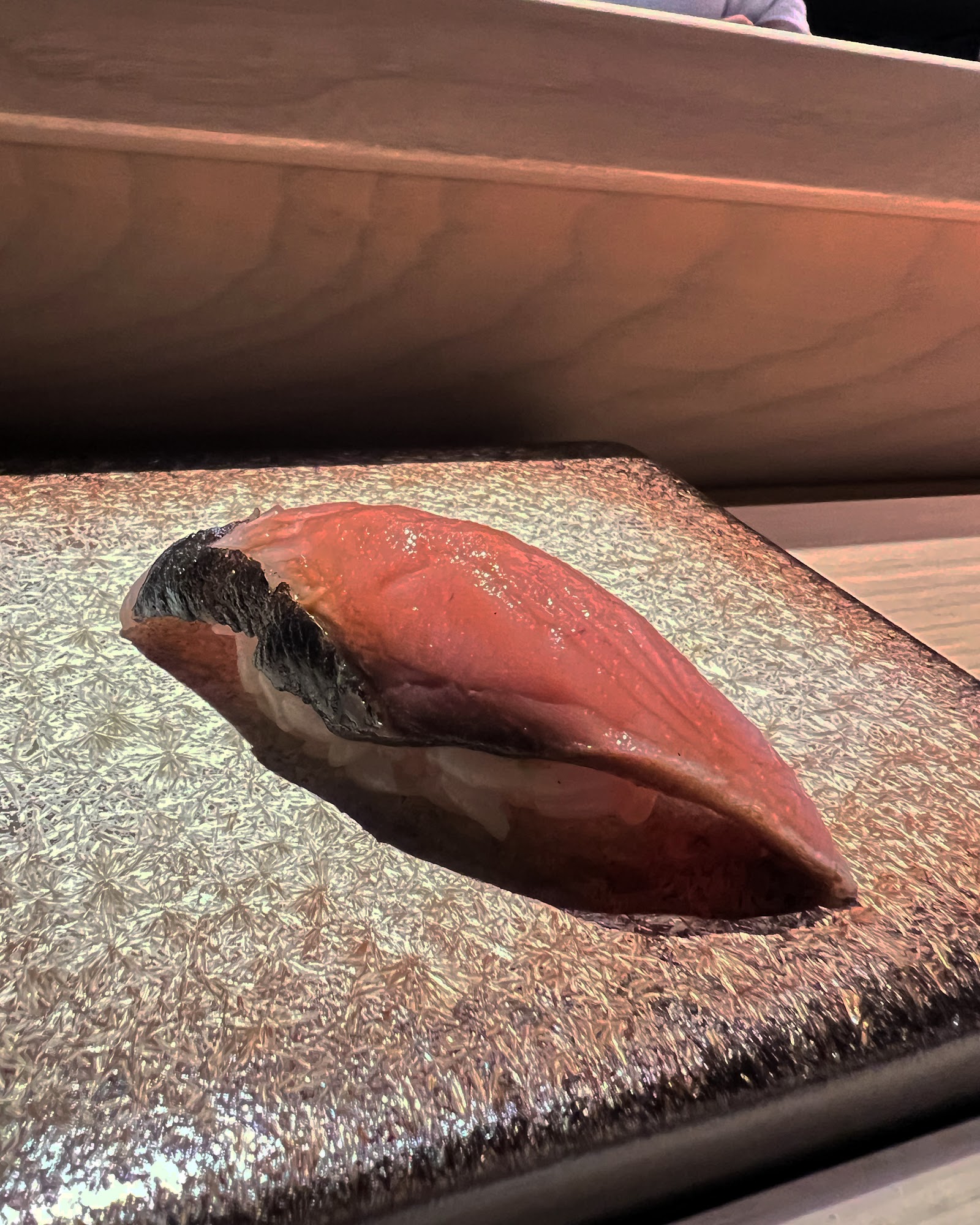 Nigiri cá ngừ trên đĩa đá dưới ánh đèn sân khấu