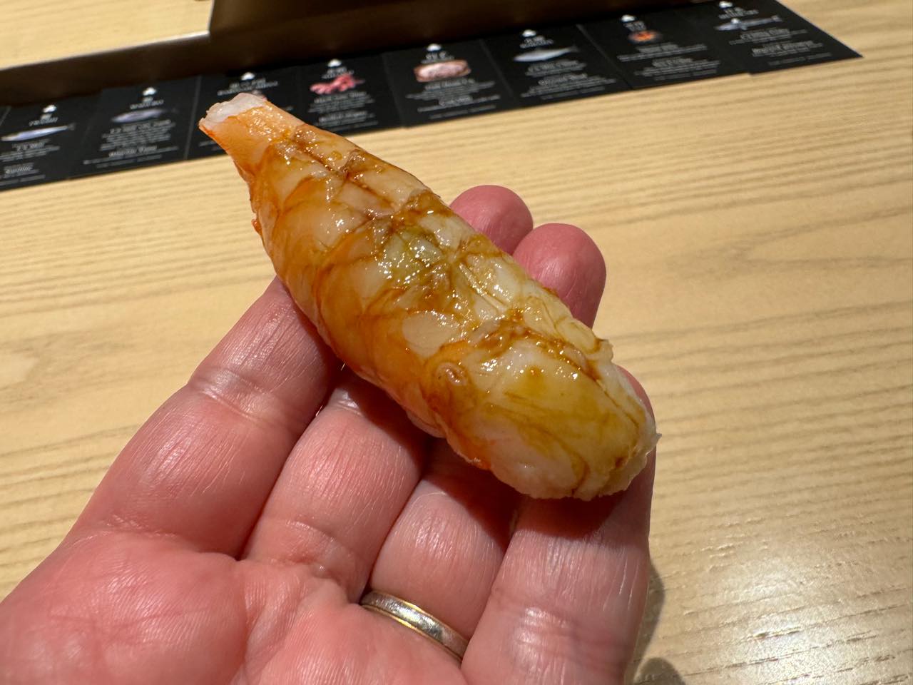 Một miếng nigiri tôm kuruma-ebi trao tay
