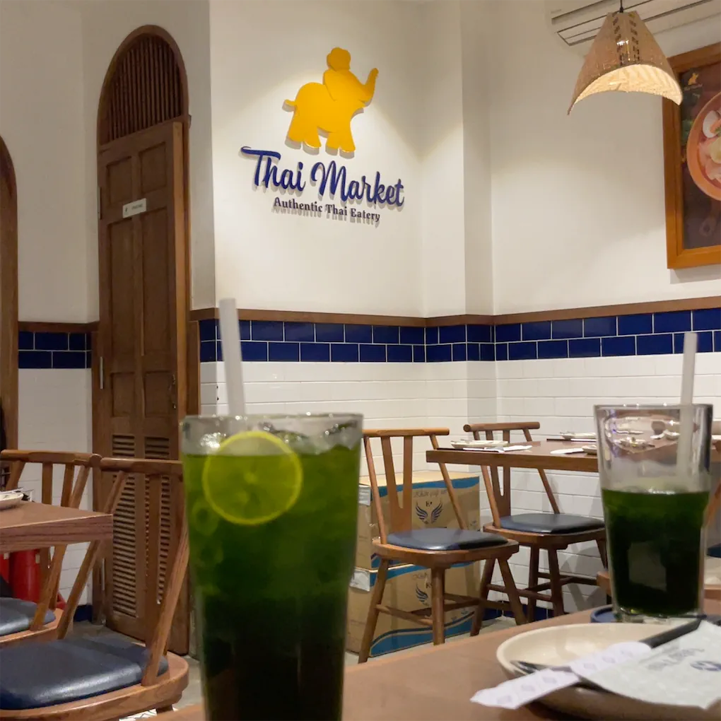 The golden elephant logo wall, blue-and-white tile, pandan drinks