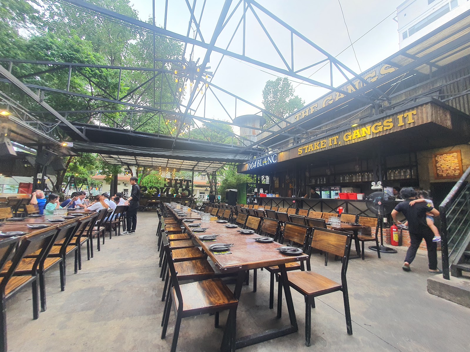 Bàn ghế gỗ dưới mái thép của The Gangs