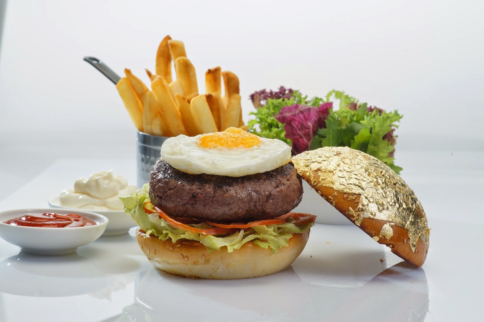 Beef burger with a gold-leaf bun, fried egg and fries