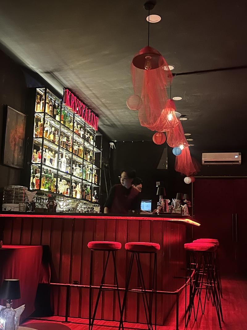 Quầy bar với bartender dưới đèn thả vải đỏ