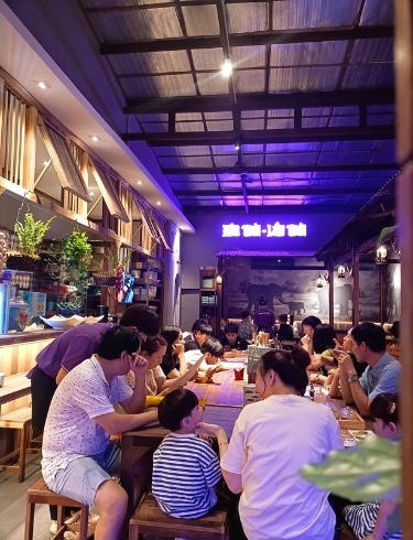 Thực khách dùng bữa trong gian phố Tiệm Ăn Siam, dưới ánh đèn tím