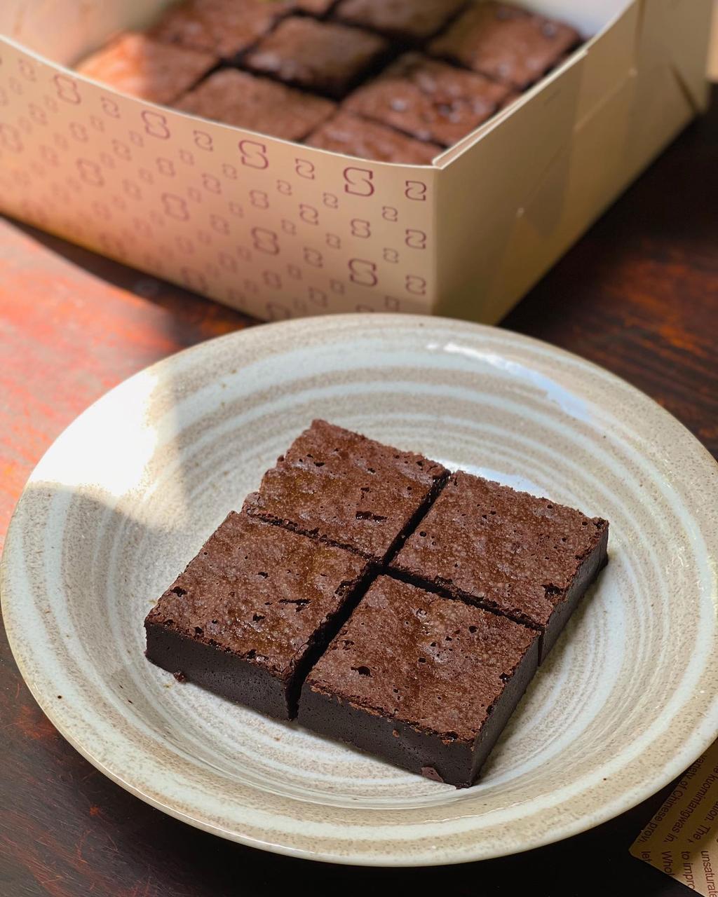 Bánh brownie và hộp bánh giấy có logo Tiệm cà phê Mơ