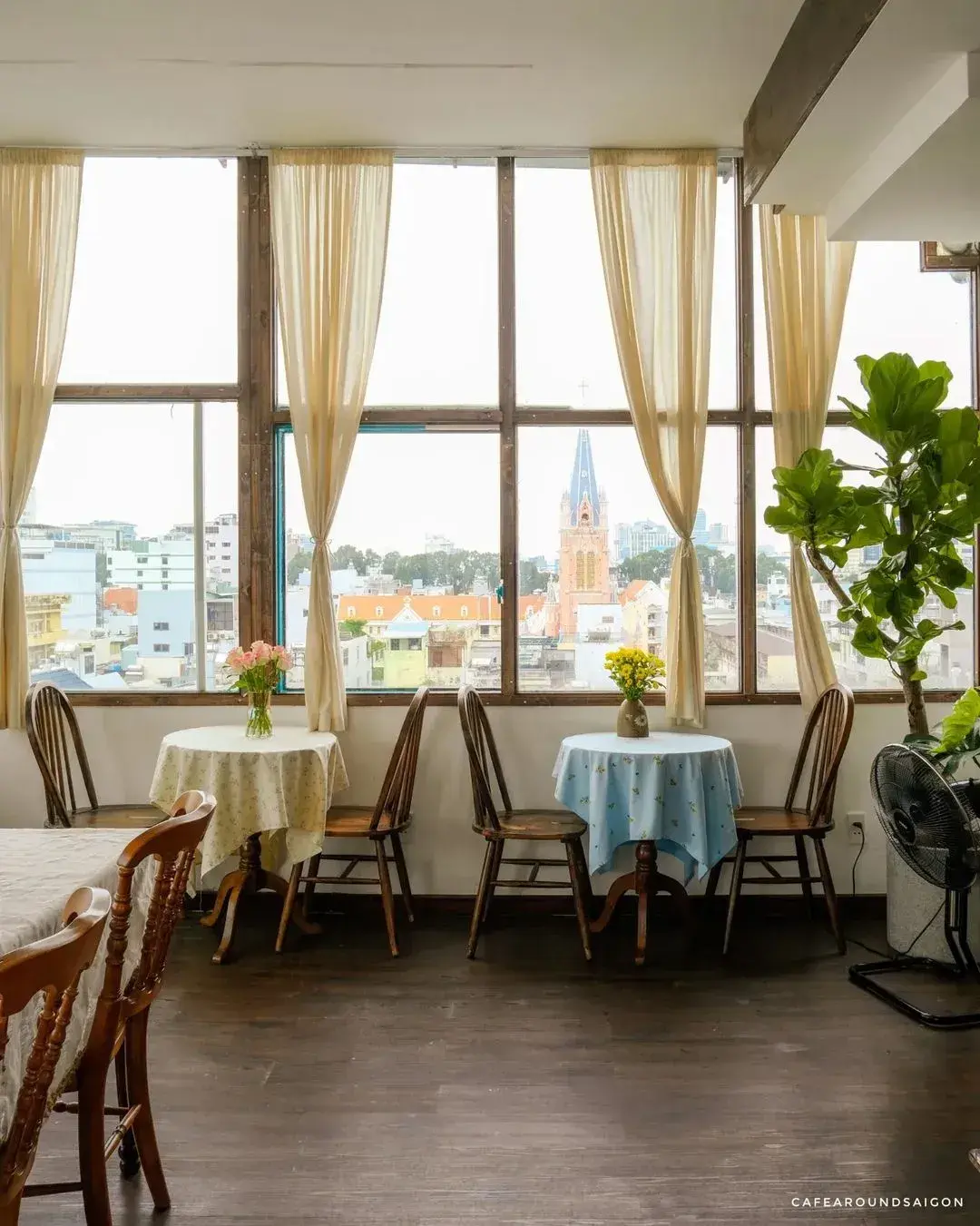 Dãy cửa sổ lớn với rèm voan nhìn ra nhà thờ