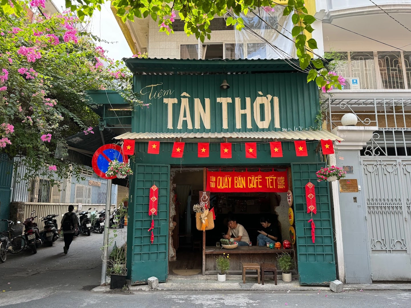 Mặt tiền tôn xanh Tiệm Tân Thời với giàn bông giấy