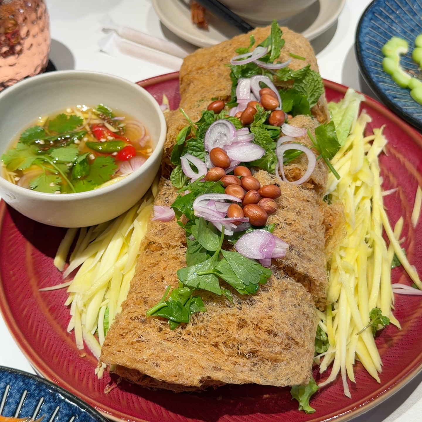 Whole crispy fried fish with green mango and peanuts