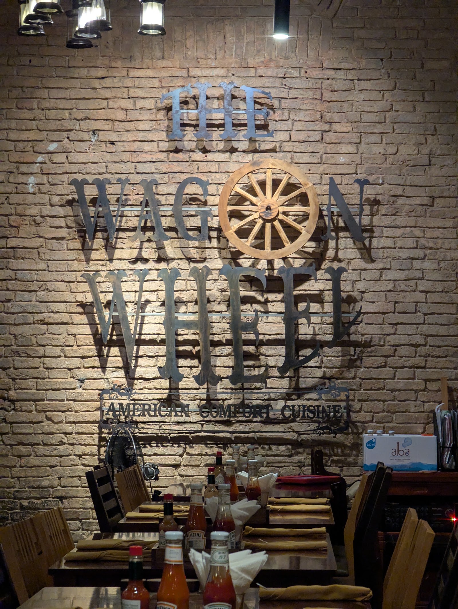 벽돌 벽 위 The Wagon Wheel의 수레바퀴 간판