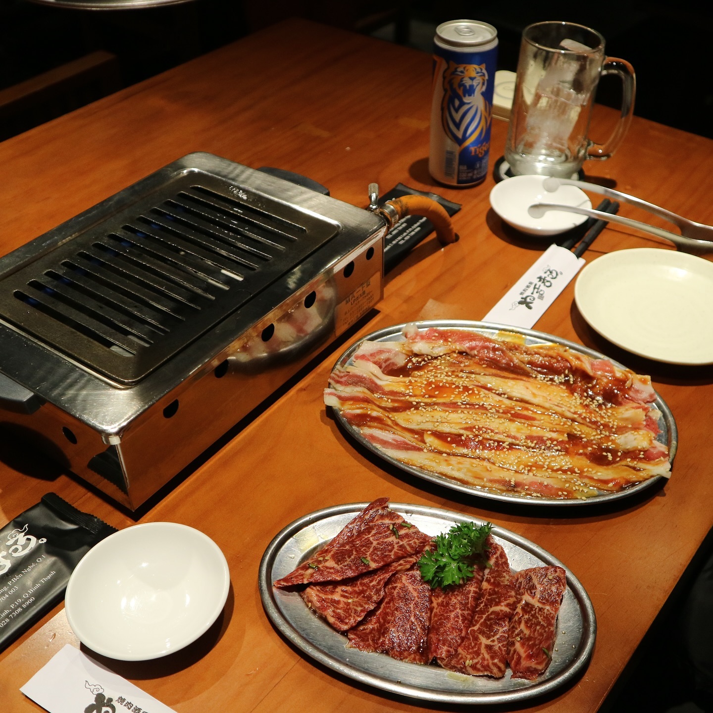 The dining table set with the gas grill and marbled meat platters