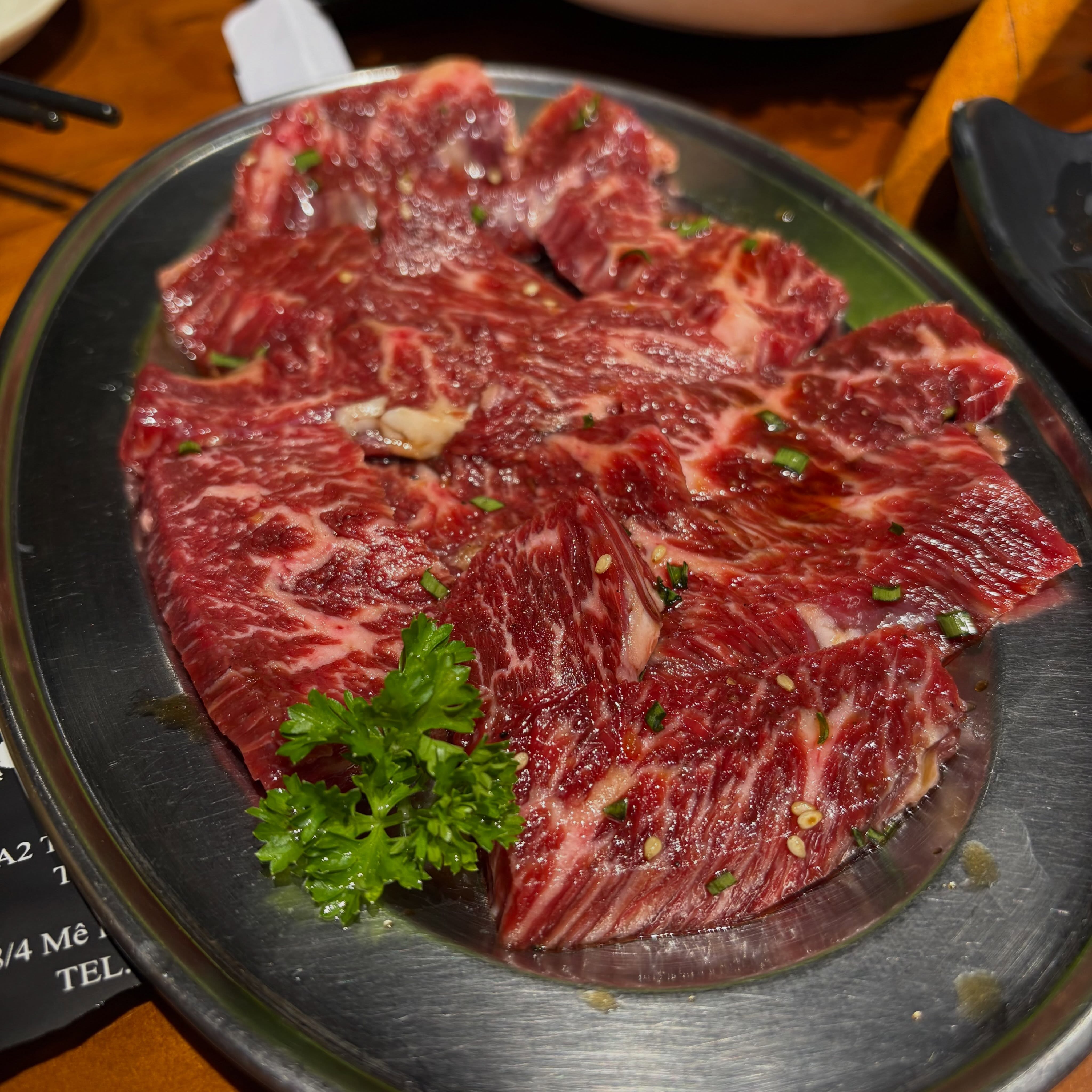 Marbled wagyu cuts on a steel plate, ready for the grill