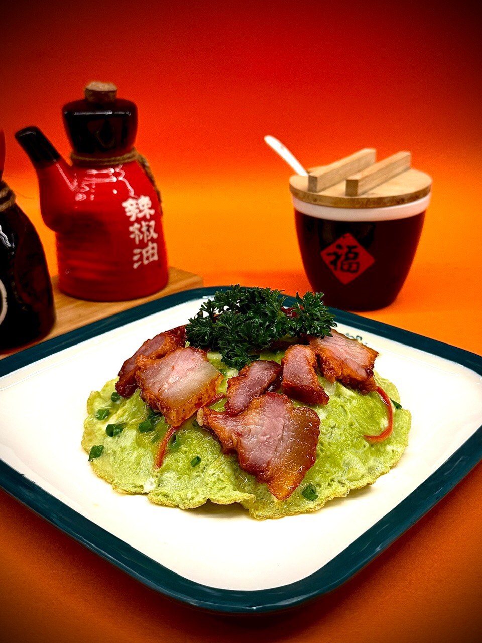 Scallion-green folded egg crowned with roast char-siu slices