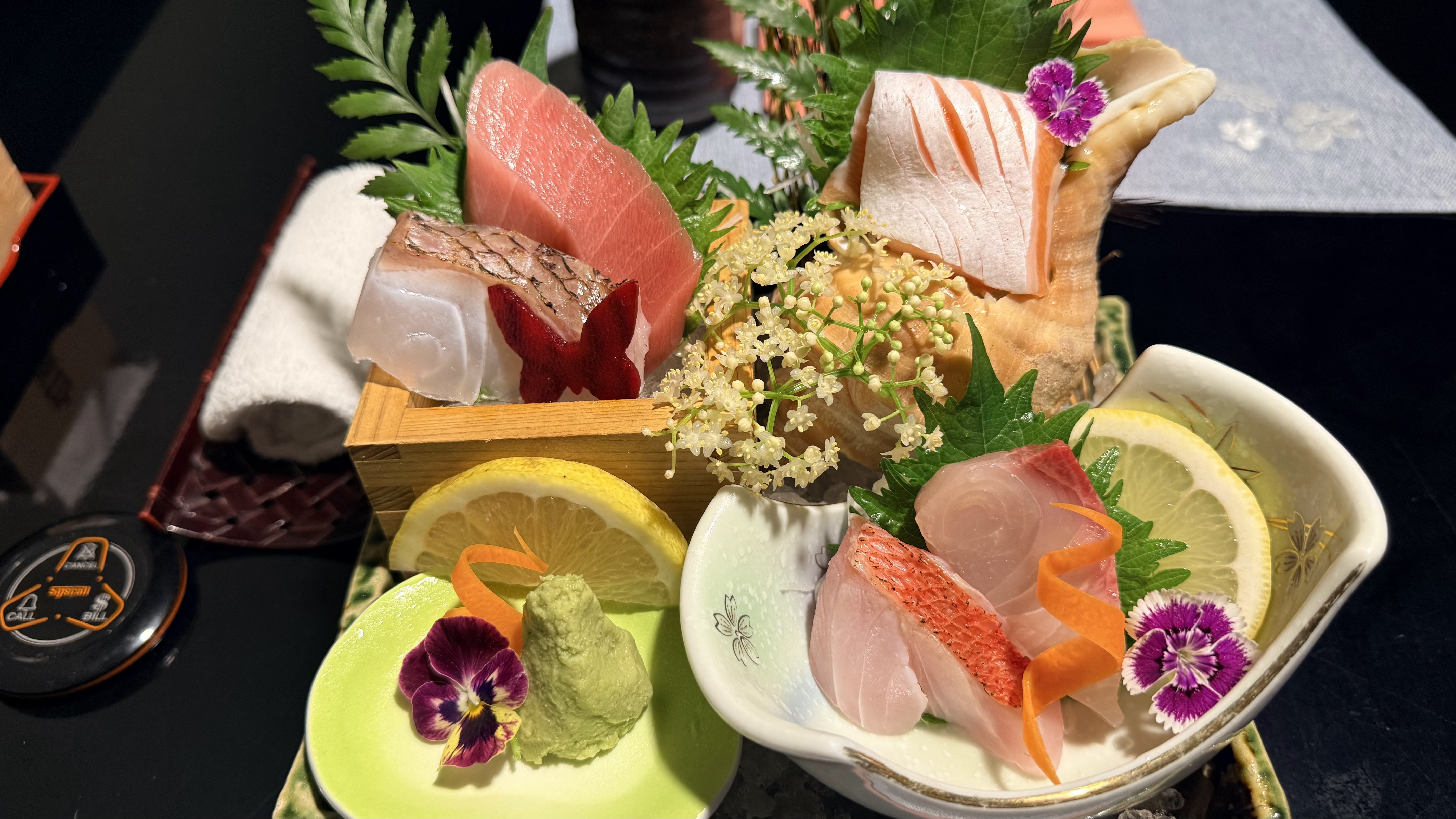 Khay sashimi moriawase cận cảnh — cá trắng, cá hồi, wasabi, chanh, hoa ăn được